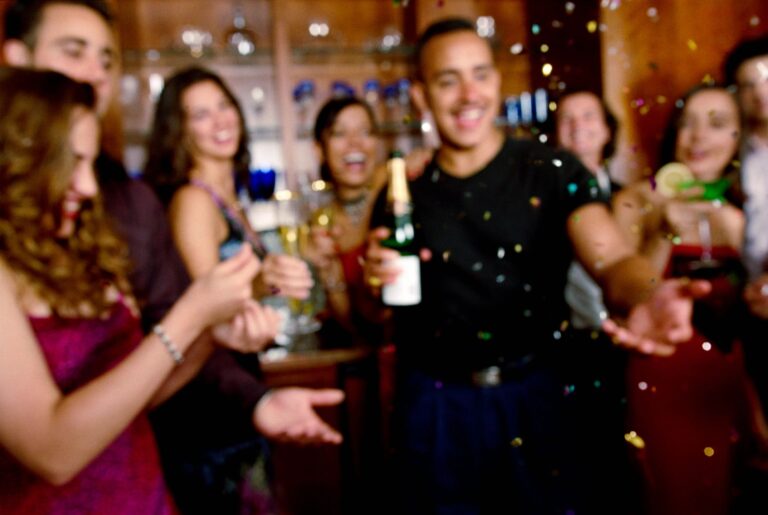 Friends celebrating with drinks in a lively bar.